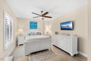 a bedroom with a bed and a ceiling fan at 1045 Wave Crest Avenue in Indialantic +44 photos