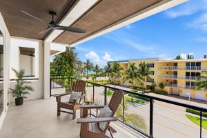 a balcony with two chairs and a view of a building at 50 8th Avenue in Indialantic