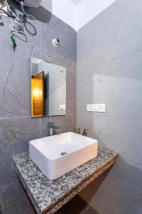 a bathroom with a white sink and a mirror at By the Lakeside in Bhīm Tāl +27 photos