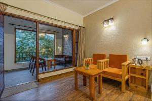 a living room with a table and chairs and a balcony at By the Lakeside in Bhīm Tāl