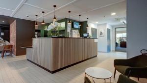 a lobby with a counter with chairs and a bar at Campanile NATURE - Vierzon in Vierzon