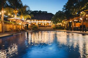a swimming pool in front of a house at night at Liberty Dive Resort in Tulamben