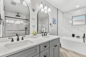 a bathroom with two sinks and a tub and a large mirror at 882 Cody Avenue in Sebastian