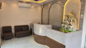 a lobby with a waiting room with a statue of people at Hotel Panchvati in Durgāpur