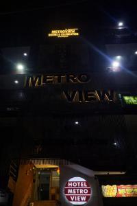 a hotel sign on the side of a building at night at HoTEL METRoVIEW in Bahādurgarh