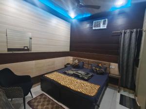 a room with a bed and a mirror and a chair at HoTEL METRoVIEW in Bahādurgarh