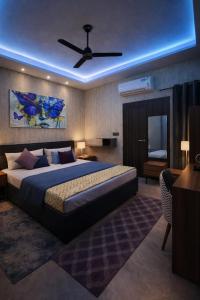 a bedroom with a large bed with a ceiling fan at HoTEL METRoVIEW in Bahādurgarh