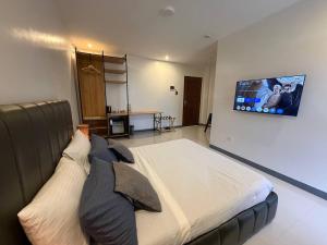 a bedroom with a large bed with a tv on the wall at Apples&Pears Hotel in Manaoag
