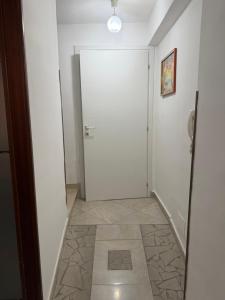a hallway with a white door and a tile floor at Il Cirismiro in Torre Faro