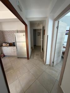 a kitchen with a refrigerator and a tile floor at Il Cirismiro in Torre Faro