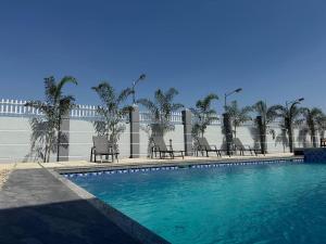 a swimming pool with chairs in front of a building at Apples&Pears Hotel in Manaoag