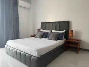 a bedroom with a large bed with blue pillows at Apples&Pears Hotel in Manaoag