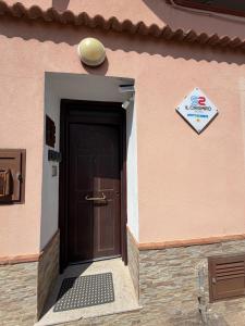 a door to a building with a sign on it at Il Cirismiro in Torre Faro