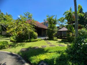 a garden in front of a house at Warung Mandi & Villa in Ubud