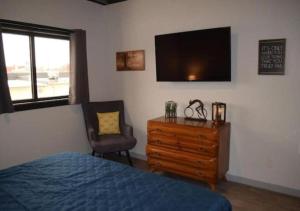 a bedroom with a bed and a dresser and a television at Rivers Edge Lofts - Unit 9 in Niles