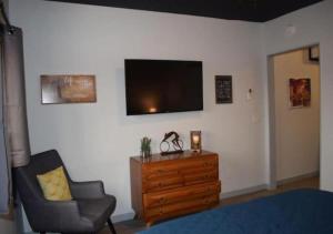 a living room with a chair and a tv on a wall at Rivers Edge Lofts - Unit 9 in Niles