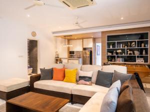 a living room with a white couch with colorful pillows at Luxe 4BR Sunset Seaview Villa Private Infinity in Plai Laem