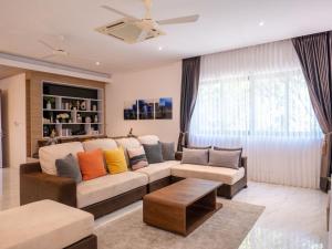 a living room with a couch and a table at Luxe 4BR Sunset Seaview Villa Private Infinity in Plai Laem