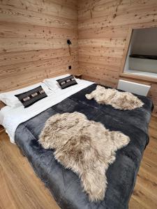 two dogs laying on a bed in a bedroom at Les Racines Chalet in Villard-Reculas