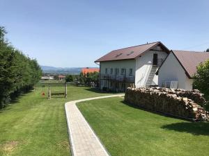 a house with a stone wall next to a yard at Apartamenty Siedlisko in Ostre