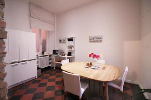 cocina y comedor con mesa de madera y sillas en Spanish Steps Art Apartment en Roma