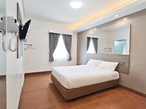 a bedroom with a bed and a tv in it at Red Planet Cagayan De Oro in Cagayan de Oro +32 photos