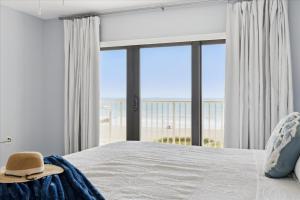 a bedroom with a bed with a view of the beach at Boardwalk 401 in Cocoa Beach