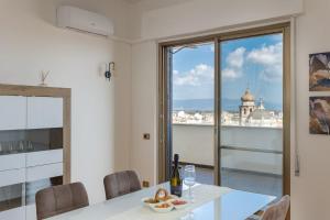 a dining room with a table and a view of the city at Penthouse Magic View - Large penthouse in the center in Oristano