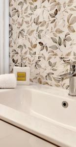 a white sink in a bathroom with a floral wallpaper at Regina Margherita in Crotone +23 photos