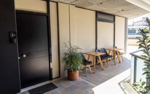 a patio with tables and chairs and a black door at Omega Suites 31 in Tríkala