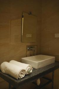 a bathroom with a sink and a mirror and towels at Aanya Taara Resort- Mettupalayam in Mettuppālaiyam +78 photos