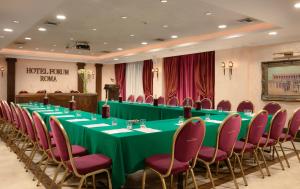 a conference room with a long green table and chairs at Hotel Forum in Rome