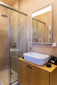a bathroom with a white sink and a shower at Omega Suites 31 in Tríkala +23 photos