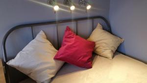 3 cuscini posti sopra un letto di Apartament Bryza a Sopot