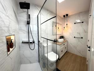 a bathroom with a shower with a toilet and a sink at Belo Horizonte Guest House in A Guarda