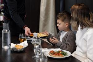 a woman and a child sitting at a table eating food at Les Boréales - Appart'hotel & Restaurant in Rouen +64 photos