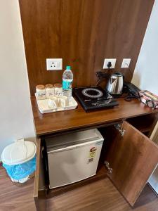 a wooden table with a counter top with a bottle of water at Veloria Grand Suites in Greater Noida