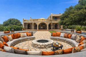 an outdoor patio with couches and a fire pit at Riad les trois merveilles in Essaouira