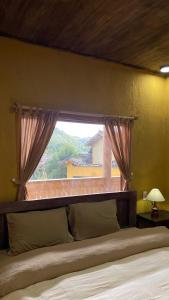 a bedroom with a large bed with a window at LoLo Hideaeay in Dồng Văn +2 photos
