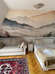 a living room with a couch and a mountain mural at Kozmáry Vendégház in Matrafured
