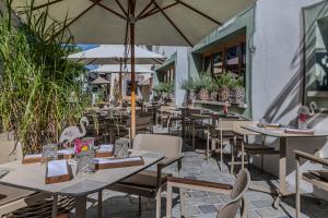 an outdoor restaurant with tables and chairs and umbrellas at Hotel Wirtshaus Post in Sankt Johann in Tirol +142 photos