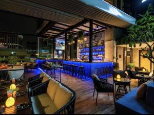 a restaurant with a bar with blue lighting at Tastoria Collection Sukhumvit in Bangkok