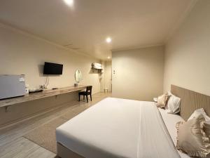 a hotel room with a large bed and a desk at Rattana View in Phitsanulok