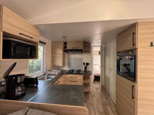a small kitchen with wooden cabinets and a sink at casa Laetitia in Lège-Cap-Ferret