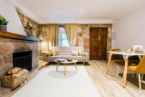 a living room with a couch and a fireplace at Apartamentos y Pensión El Campanu in Cangas de Onís