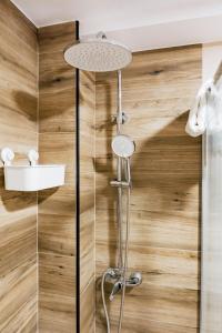 a shower in a bathroom with wooden walls at Apartamentos y Pensión El Campanu in Cangas de Onís +39 photos