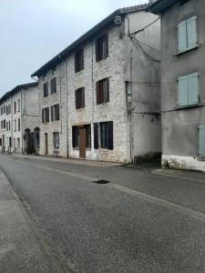 an empty street next to an old stone building at les ruffins in Saint-Jean-en-Royans