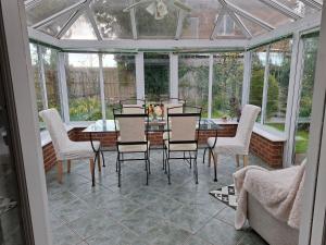 a conservatory with a table and chairs in a room at Annasrose cottage in Middlesbrough