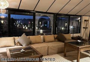 a living room with a couch and a table at Sahara Luxurious Tented in Merzouga