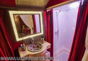 a bathroom with a sink and a mirror and a shower at Sahara Luxurious Tented in Merzouga +28 photos